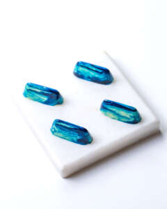 side view white blue chocolate candy on a white stand